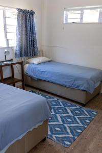 a bedroom with two beds and a table and a window at A Stone's Throw from the Ocean in Seafield