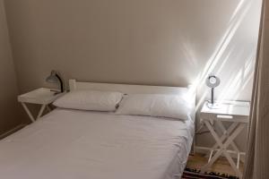 a bedroom with a white bed and a desk at A Stone's Throw from the Ocean in Seafield +4 photos