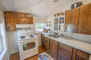 une cuisine avec des armoires en bois et un four blanc dans l'établissement BnBs Dog Friendly Cottage, à Lewes