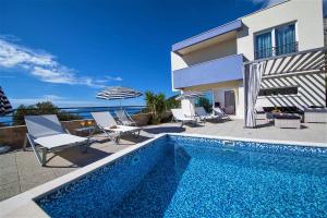 a swimming pool in front of a house at Villa Red with pool and sea view in Makarska