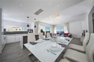 a dining room and kitchen with a white table and chairs at Villa Red with pool and sea view in Makarska