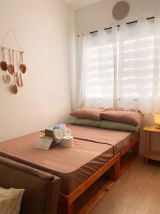a bed sitting in a room with a window at Cozy Condo near Mactan Airport - Free Wifi! in Lapu Lapu City