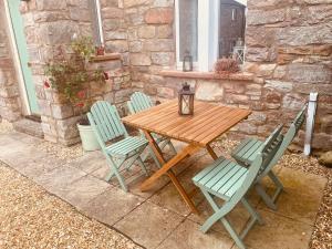 a wooden table with four chairs and a lamp at Idyllic Two bed country cottage in Kirkby Thore