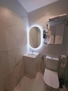 a white bathroom with a toilet and a sink at Hostal San Blas in Madrid