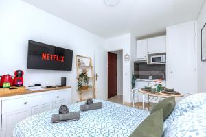 Un pequeño dormitorio con una cama y una cocina. en Studio cosy 2P - Proche Versailles/Paris, en Le Chesnay