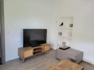 a living room with a large flat screen tv at Modernes Apartment direkt am Strand in Chrysi Ammoudia