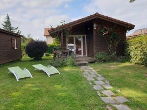 two white chairs and a house in a yard at Chalet Edelweis in Plombières-les-Bains