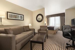 a hotel room with a couch and a bed at Country Inn & Suites by Radisson, Dixon, CA - UC Davis Area in Dixon