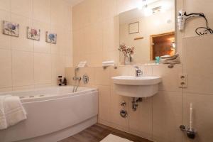 un bagno con un lavandino, una vasca da bagno e un lavandino di Haus-Ostseeapartments-am-Fehmarnsund-Wohnung-24-SUeDSTRANDBLICK a Grossenbrode Altre 14 foto