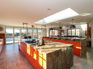 una gran cocina con armarios naranjas y una gran isla en Royal Oak House, en Shaftesbury