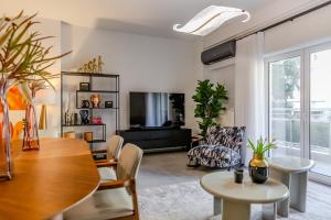 Una sala de estar con una mesa y un televisor. en Elysian Condo, Koukaki, en Atenas