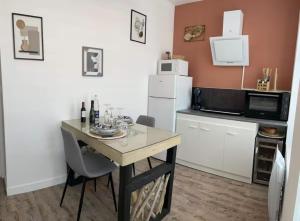 a small kitchen with a table and a refrigerator at Au spa de clem in Guemps