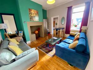 a living room with a blue couch and a table at Spacious room, close to city centre in Walker Gate