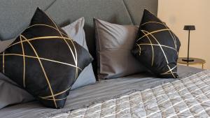 a bed with black and gold pillows on it at Room with free parking 15 minutes walk from Arena in Verona