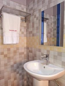 a bathroom with a sink and a mirror and a towel at Smart Beach Resort Hotel Mityana in Mityana