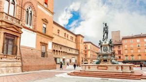 een standbeeld in het midden van een stad met gebouwen bij Concerti, Stadio e Aeroporto Bologna in Bologna