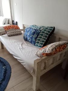 una cama de madera con almohadas en una habitación en Ocean view diani, en Ukunda