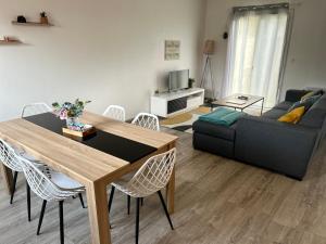 salon ze stołem i kanapą w obiekcie Maison Mitoyenne avec cour + parking w mieście Sainte-Savine
