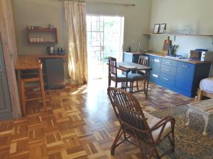 a kitchen with wooden floors and a table and chairs at The Homestead - Simple Farm-Style Accommodation in Port Alfred