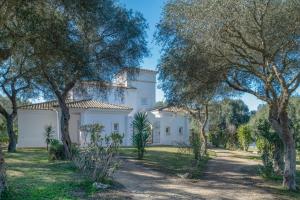 ein großes weißes Haus mit Bäumen im Vordergrund in der Unterkunft Villa Albatros in Benalup Casas Viejas