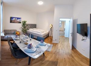 a dining room and living room with a table and chairs at Art Living Vienna in Vienna