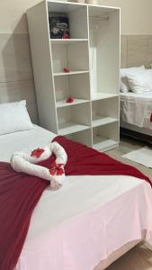 a white bed with red and white towels on it at Casa da Cida in Fernando de Noronha