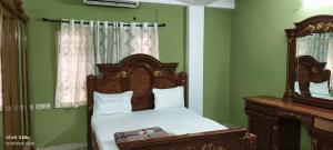 a bedroom with a bed with a wooden headboard and a mirror at Hill Street Service Apartments in Hyderabad