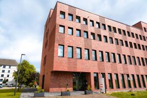 a red brick building with windows on a street at havenstudios Bremerhaven in Bremerhaven
