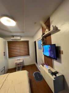 una camera da letto con un letto e una TV a parete di LOGA Apartment a Lagos