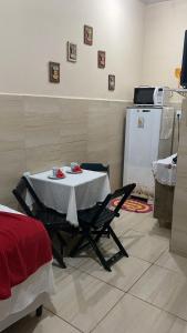 a table and chairs in a kitchen with a refrigerator at Casa da Cida in Fernando de Noronha