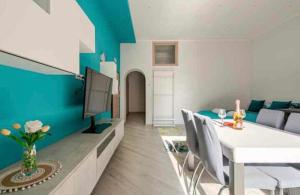 a living room with a white table and a blue wall at Casa Vacanze San Giacomo Comfort Apartment in Centro a pochi passi dal Mare in Barletta