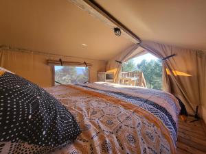 a bedroom with a bed in a tent at Camping le Cézanne Montagne Sainte-Victoire in Puyloubier