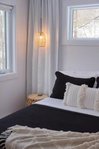 a bedroom with a bed and a window and a lamp at Armoni Ski & Spa in Cantley