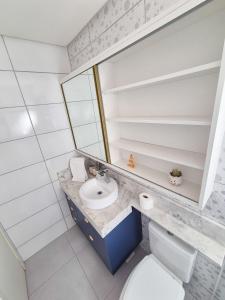 a bathroom with a sink and a mirror at Casa no segundo andar na Praia da Cal com ar e sacada in Torres
