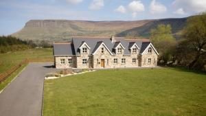 een groot huis met een groot gazon ervoor bij Yeats Lodge in Drumcliff