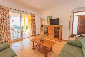 ソン・ボウにあるVilla Laurinda - Near the beachのテレビとテーブルのあるリビングルーム