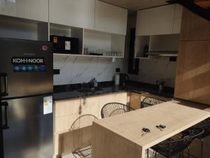 a kitchen with a counter with chairs in it at Loft CienHojas in San Luis +4 photos