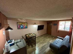 a living room with a couch and a table at Departamento a 2min de Playa la Madera in Zihuatanejo