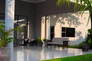 a porch of a house with a couch and plants at Bhejane Lodge in Victoria Falls