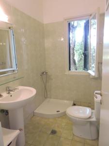 a bathroom with a sink and a toilet and a window at Summerhouse Marianna in Ixia