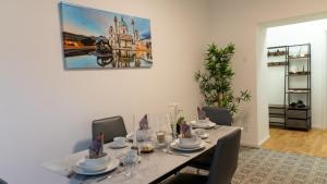 a dining room table with chairs and a painting on the wall at Art Living Vienna in Vienna