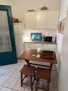 a kitchen with a wooden table and a microwave at Summerhouse Marianna in Ixia +12 photos