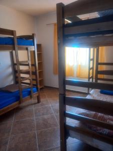a room with three bunk beds and a window at Pousada Malu III in Bragança Paulista