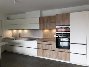 a kitchen with white cabinets and a black oven at Henea in Saint-Paul-lès-Dax