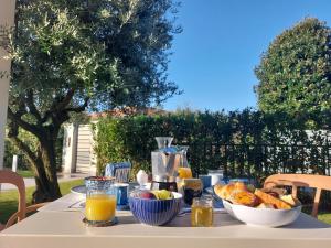 a table with a breakfast of orange juice and bread at Slowersilia Bed and Breakfast in Lido di Camaiore