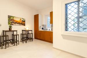 a kitchen with three bar stools and a window at Vatican Cipro Guest House in Rome
