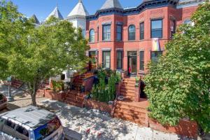 une maison en briques rouges avec une camionnette garée devant dans l'établissement Boho Bliss Bloomingdale plus Parking, à Washington