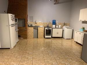 a kitchen with white appliances and a tile floor at Show rural centro de cascavel in Cascavel