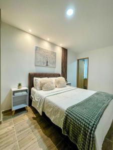 a bedroom with a large bed and a table at 601S Penthouse moderno con Parqueo Incluido in Ibagué
