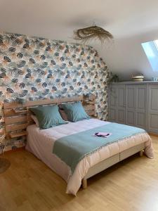 a bedroom with a large bed with a wall at Entre terre et baie in Pontaubault
